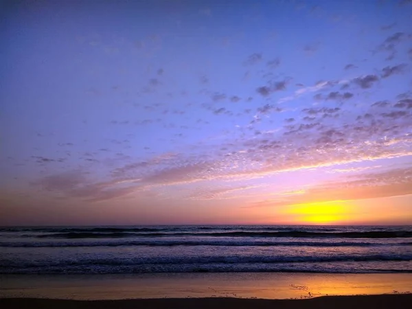 Tiro do céu amarelo e roxo durante o pôr do sol da praia de Cádiz, Espanha. — Fotografia de Stock