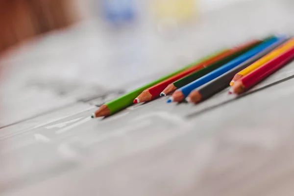 Encerramento tiro de lápis de desenho colorido em uma superfície turva — Fotografia de Stock