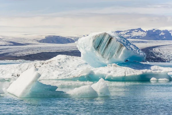 Bellissimo scatto di un iceberg con montagne sullo sfondo — Foto Stock