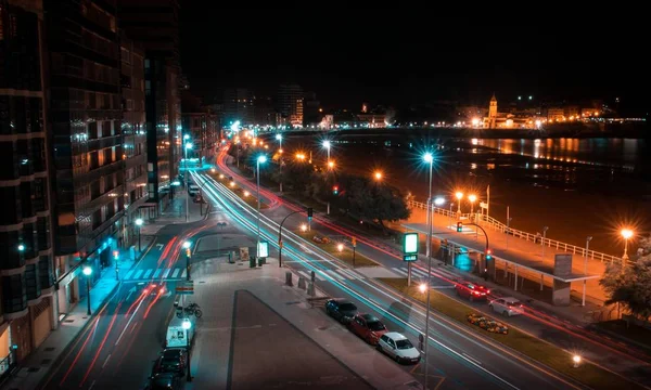 Ciudad de Gijón rodeada de luces durante la noche con efecto de movimiento en España. — Foto de Stock