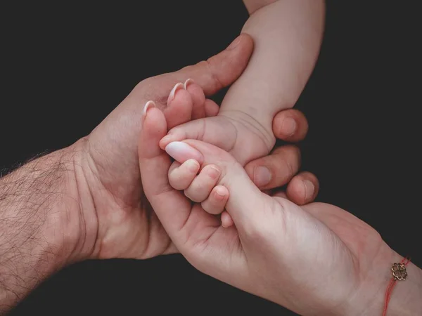 Vrouw en man met pasgeboren baby 's hand — Stockfoto