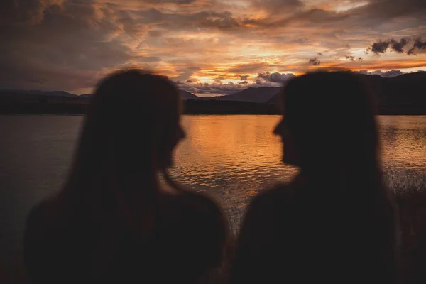 Filles assises sur le rivage au coucher du soleil au lac Polka, en Nouvelle-Zélande — Photo