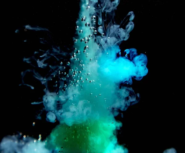 Abstract concept of teal and green color ink drop plume in water on an isolated  black background — Stock Photo, Image