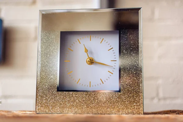 Közelkép egy négyzet alakú óra arany nyilakkal — Stock Fotó