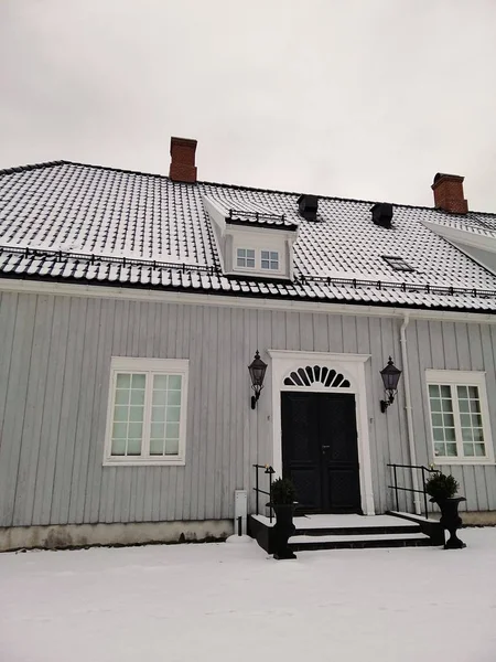 Verticale foto van een huis omringd door de sneeuw onder een bewolkte lucht in Larvik in Noorwegen — Stockfoto