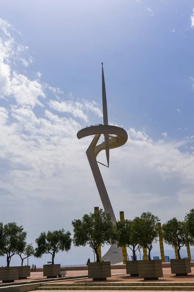 Montjuic Communications Tower omringd door bomen onder het zonlicht en een bewolkte hemel in Spanje — Stockfoto