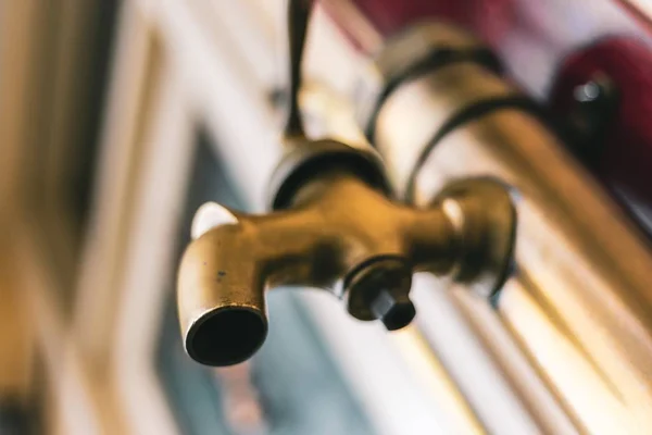 Botão de fechamento de ângulo baixo de uma torneira de pia antiga dourada — Fotografia de Stock