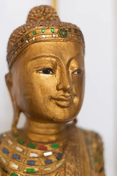 Függőleges közelkép egy homályos hátterű arany ázsiai szoborról — Stock Fotó