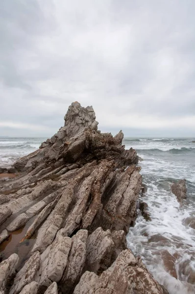 Foto vertical de las olas que chocan contra las rocas de la playa de Sopelana, en Vizcaya, España. — Foto de Stock