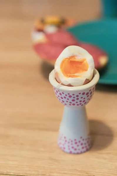 Vertical shot of a soft boiled egg in an egg cup or egg server