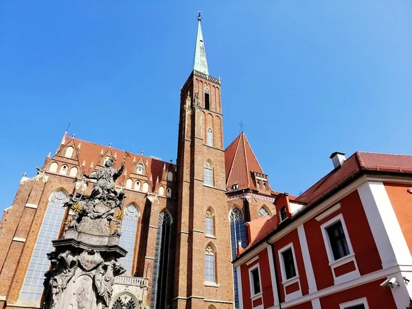 Onderaanzicht op de toren en het standbeeld buiten de kathedraal van St. Johannes de Doper in Warschau — Stockfoto
