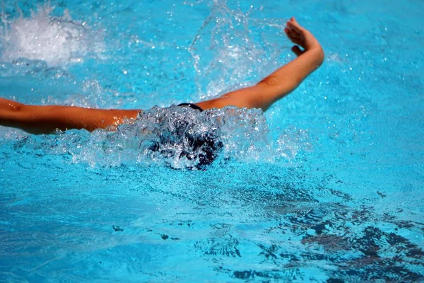 Nahaufnahme einer professionellen Schwimmerin, die Schmetterling im Schwimmbad übt — Stockfoto