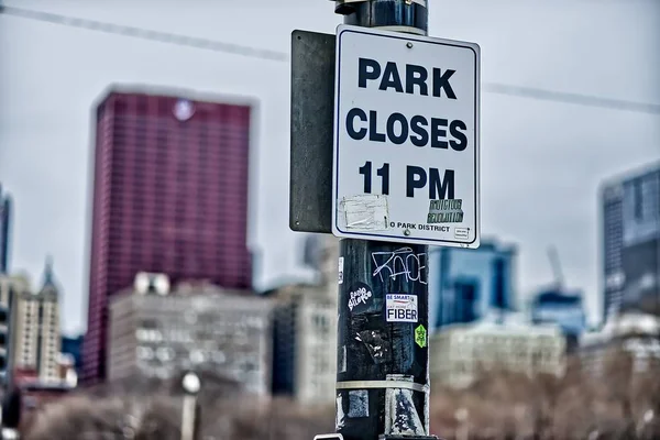 Teken op de lantaarnpaal dat het park over 23: 00 uur sluit. — Stockfoto