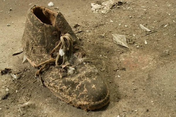 Крупним планом знімок старого зношеного брудного черевика на землі — стокове фото