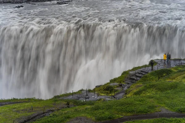 Schöne Aufnahme eines Wasserfalls mit Menschen, die in seiner Nähe stehen — Stockfoto