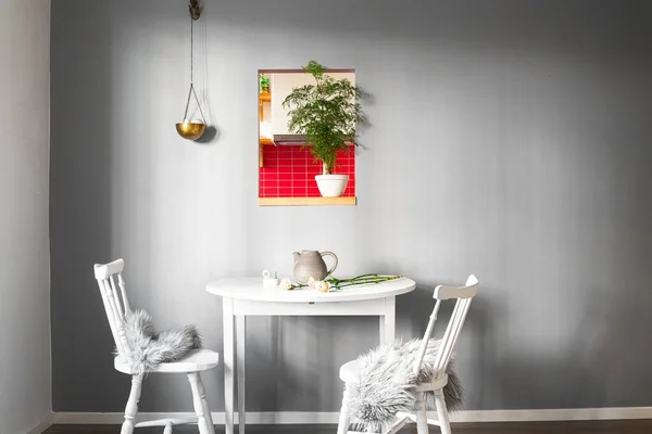 Güzel bir iç mekanı ve duvarında resmi olan bir odada iki sandalyeli beyaz bir masa. — Stok fotoğraf
