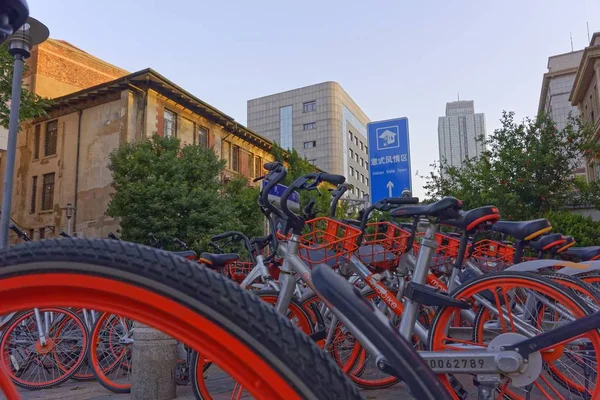 Κοντινό πλάνο αρκετών κόκκινων ποδηλάτων που σταθμεύουν το ένα δίπλα στο άλλο και περιβάλλονται από κτίρια — Φωτογραφία Αρχείου