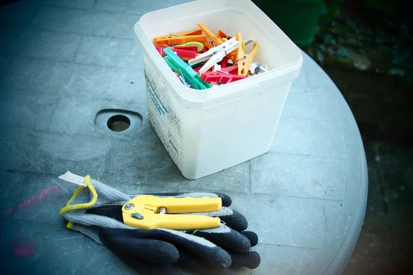 Vue à angle élevé de pinces à linge multicolores à côté d'un outil et de gants — Photo