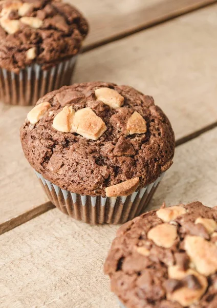Tres muffins de chocolate alineados diagonalmente. Imagen vertical — Foto de Stock
