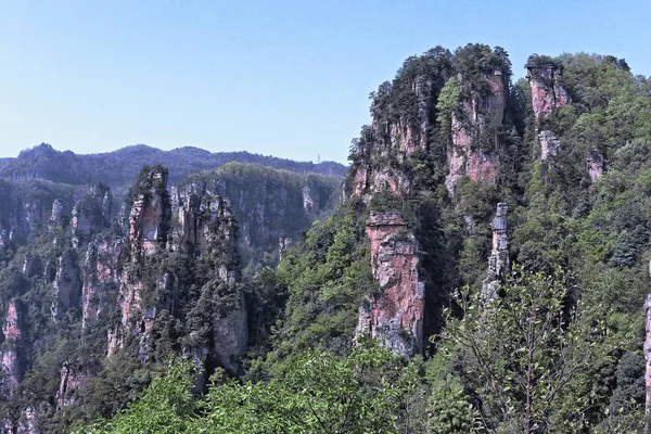 Klippe neben dem Berg mit Bäumen und Vegetation bedeckt — Stockfoto