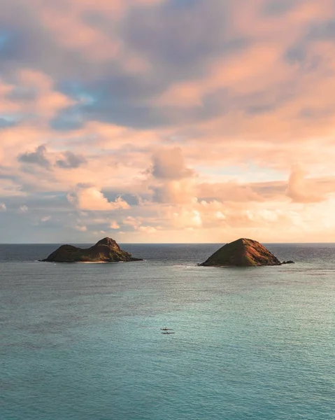 Bellissimo scatto di piccole colline nel mare sotto il bel cielo nuvoloso — Foto Stock