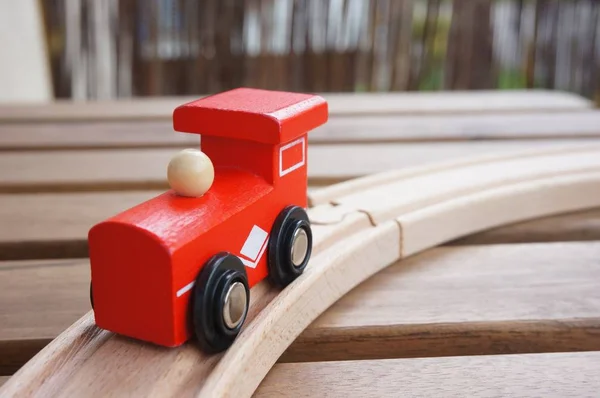 Encerramento tiro de um trem de brinquedo de madeira vermelha em um trilho de madeira — Fotografia de Stock