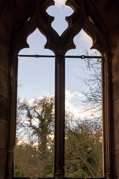 Foto vertical de una vieja ventana en forma de arco con vistas al parque. — Foto de Stock