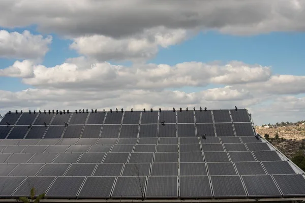 Vue à grand angle de panneaux solaires sur le toit avec des nuages à l'arrière-plan — Photo