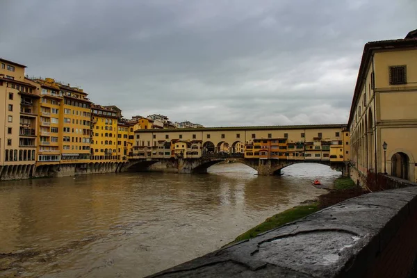 Ponte Vecchio nad řekou Arno obklopen budovami ve Florencii v Itálii — Stock fotografie