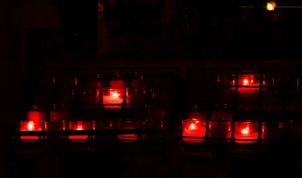 Rote Kerzen in Glascontainern in einem dunklen Raum — Stockfoto