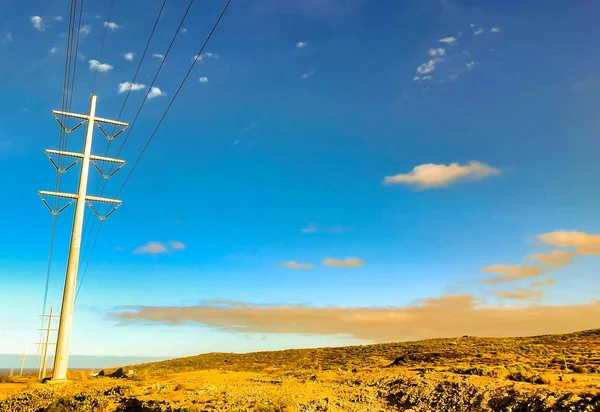 Piękne ujęcie przewodów elektrycznych na polu pod zachmurzonym niebem na Wyspach Kanaryjskich, Hiszpania — Zdjęcie stockowe