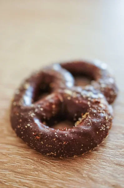 나무 표면에 초콜릿을 입힌 맛있는 프레첼을 클로즈업 한 사진 — 스톡 사진