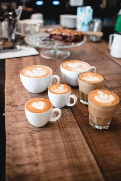 Een Verticaal Shot Van Cappuccino Cups Met Verschillende Figuren Erin — Stockfoto
