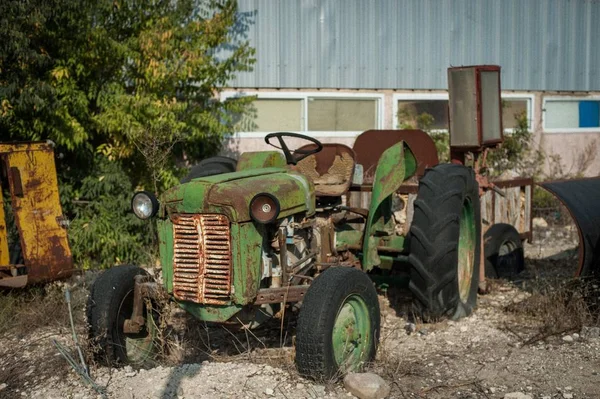 Vecchio camion verde arrugginito danneggiato parcheggiato di fronte a un garage — Foto Stock