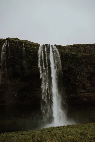 Beau paysage d'une cascade puissante près de hautes falaises rocheuses — Photo