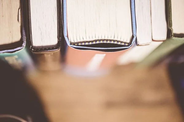 Encerramento tiro de diferentes livros em uma prateleira com um fundo borrado — Fotografia de Stock