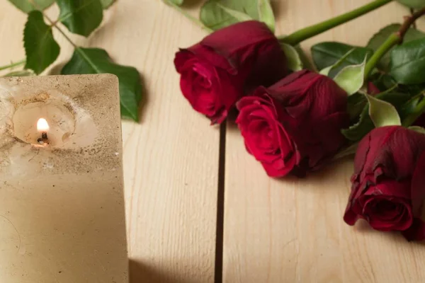 Bougie et roses rouges sur une surface en bois - concept de jour valentins — Photo