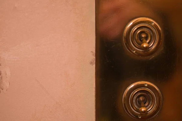 El disparo de cierre de los interruptores de toggle de bronce sobre una superficie de bronce. —  Fotos de Stock