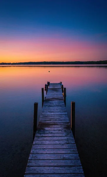 Мбаппе сделал снимок заката в заливе спокойного озера с причалом — стоковое фото
