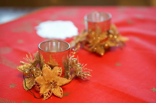 빨간 탁자 위에 있는 작은 금속 꽃들 에둘러 싸여 있는 촛불 소지자들 — 스톡 사진