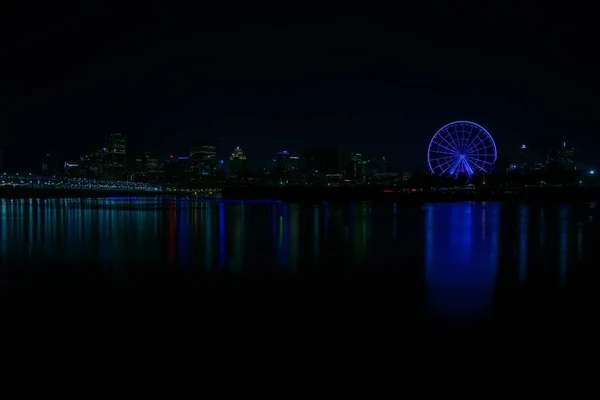 Skyline noturno no Parque Dieppe com roda gigante iluminada e reflexos claros sobre o rio — Fotografia de Stock