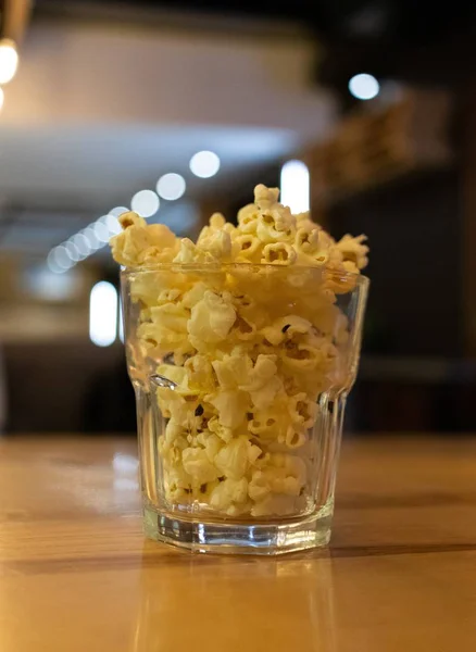 Krásný záběr popcornu ve sklenici na dřevěném stole kavárny — Stock fotografie
