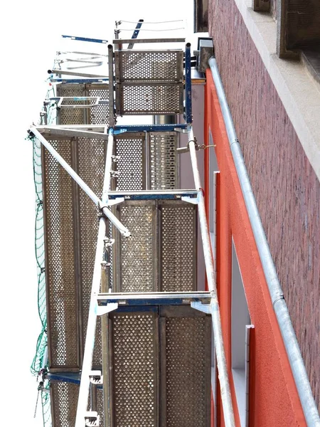 Colpo verticale di costruzione in metallo di fronte a un edificio — Foto Stock
