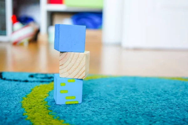 Speelgoed van meerdere kleuren bovenop elkaar op een veelkleurig tapijt — Stockfoto