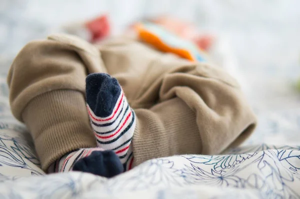 Beautiful shot of the cute little feet of a baby lying on a bed — Stock Photo, Image