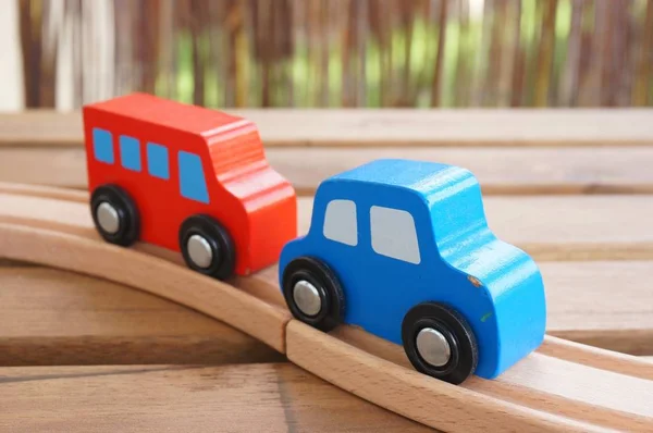 Closeup tiro de brinquedo azul de madeira carro vermelho brinquedo de madeira ônibus em uma pista de madeira — Fotografia de Stock