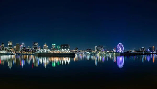 Nachtelijke skyline in Dieppe Park met een verlicht reuzenrad en lichtreflecties op de rivier — Stockfoto