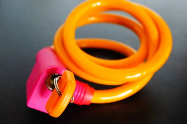 Närbild av rosa och orange kabel lås på ett träbord under lamporna — Stockfoto
