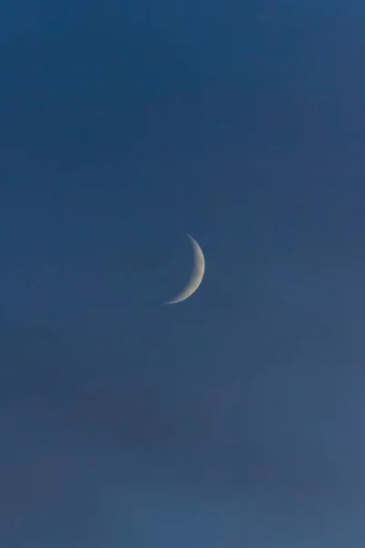 Tiro vertical de uma lua jovem em um céu azul em zíper, croatia — Fotografia de Stock