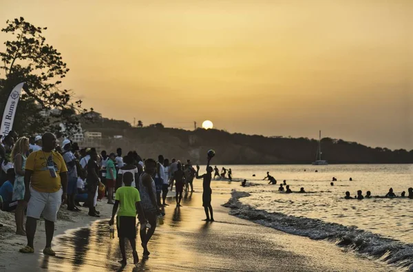 Gün batımında yüzen ve plajda oynayan insanların fotoğrafları. — Stok fotoğraf